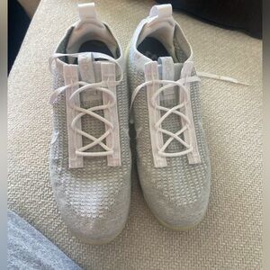 Vapormax grey and white Nike shoes.